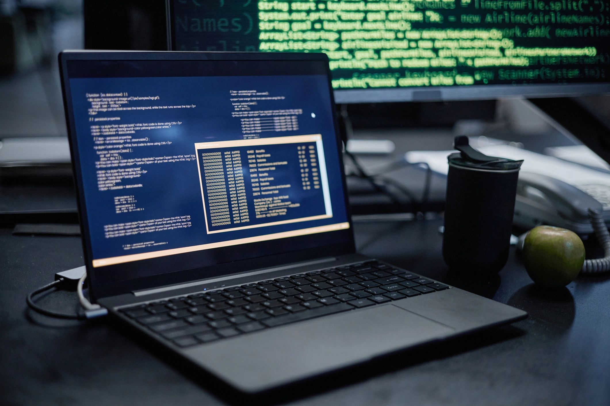 Laptop displaying code on a desk